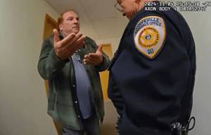 KOMO image
Body-cam video shows Tim Hazelo speaking with the Coupeville marshal in the elections office.