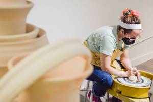 Whidbey Clay Center instructor Jordan Jones demonstrates shaping a lump of clay into a gumdrop shape and centering the hole during her class at the Whidbey Clay Center in Freeland. Centering the holes is an important first step to turn clumps of mud into art, whether it be a mug, bowl, spoon rest, dragon, wagon or farm animal. (Patricia Guthrie / Special to The Herald)