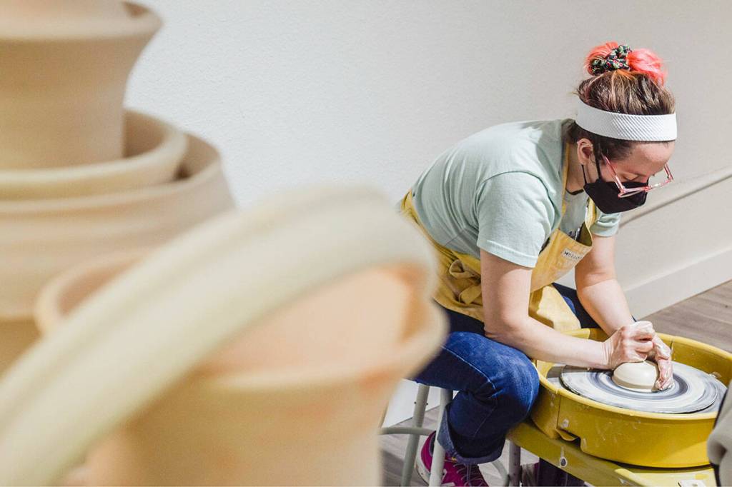 Whidbey Clay Center instructor Jordan Jones demonstrates shaping a lump of clay into a gumdrop shape and centering the hole during her class at the Whidbey Clay Center on Wednesday, Jan. 8, 2025 in Freeland, Washington. Centering the holes is an all-important first step to turn clumps of mud into art, whether it be a mug, bowl, spoon rest, dragon, wagon or farm animal. (Patricia Guthrie / Special to The Herald)