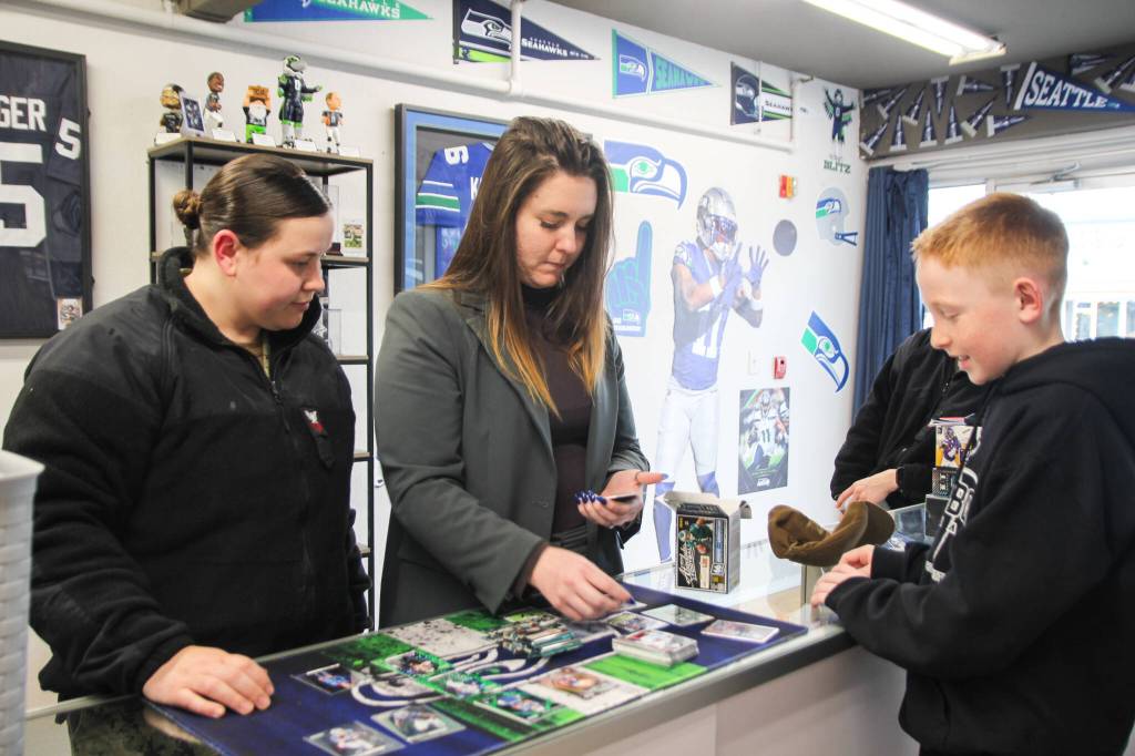 At left, Emily Lamb, Taylor Puckett and Hunter Meyer look at cards. (Photo by Luisa Loi)