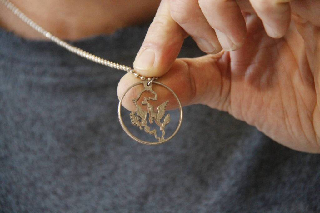 (Photo by Kira Erickson/South Whidbey Record)
Chris Soukup shows off his own necklace, the outline of Whidbey Island carved into a U.S. 50-cent piece. He kept the wings of the eagle on the half dollar.