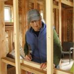 (Photo by Kira Erickson/South Whidbey Record)
Cary Peterson, project lead and founder of Whidbey Home-Raising, hammers a nail as she begins the blocking process for a recessed medicine cabinet.