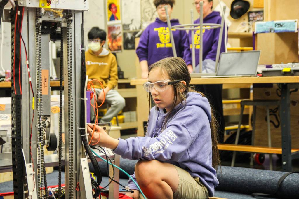 Ninth grader Thorin Allen works on Evb0t, the robot he got to name after winning a pillow fight. Evb0t was named after the main character in a YouTube Minecraft movie. (Photo by Luisa Loi)