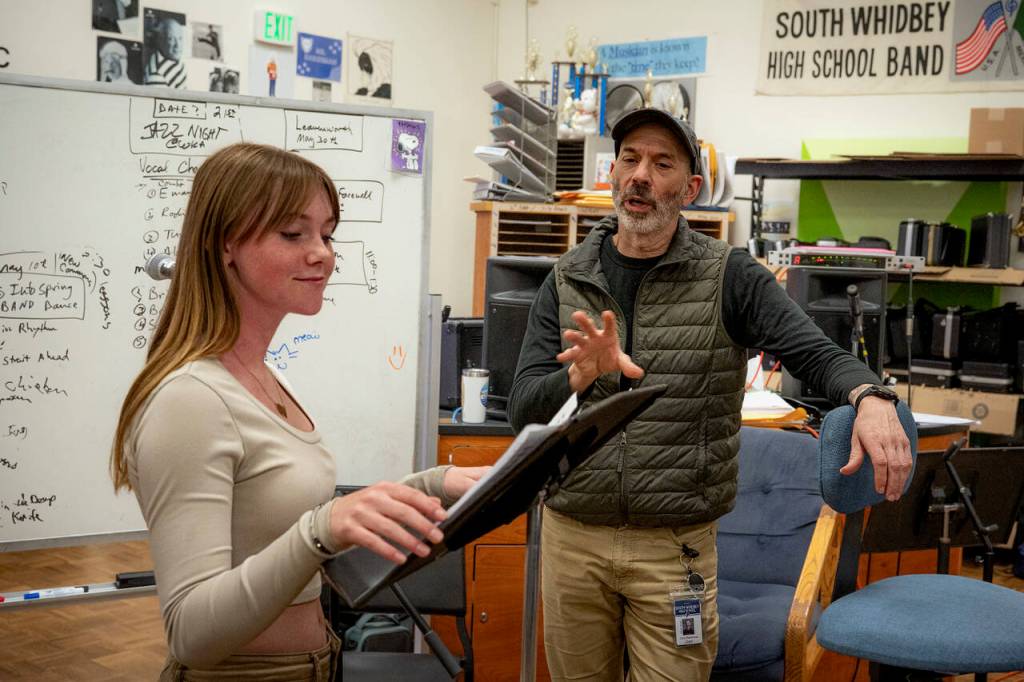 Chris Harshman works with eighth grader Emma-Tara Lee on her voice skills before singing Rolling in the Deep. (Photo by David Welton)