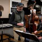 The music director shares a light moment with saxophonist Liam Watkins. (Photo by David Welton)