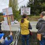 Protests hold signs in Bayview on the day that shots were heard from a nearby residence. (Photo by Barbara Wolf Terao)