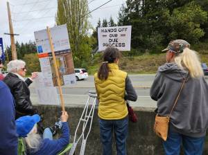 Protests hold signs in Bayview on the day that shots were heard from a nearby residence. (Photo by Barbara Wolf Terao)