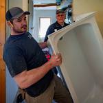 Bruce Schwager, a captain for Keira Kingfisher home project, help with Isaac Leitz wrestle a tub.