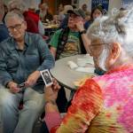 Vicki Robin, right, gazes at a card printed with a photo of Jimmy Scullin as Clarence the angel, from “It’s a Wonderful Life” play at WICA in 2019.