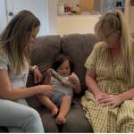 Photo courtesy of Mother Mentors
Cherie Schierholtz and her son Jessie read a book with volunteer mentor Wren Whitman.