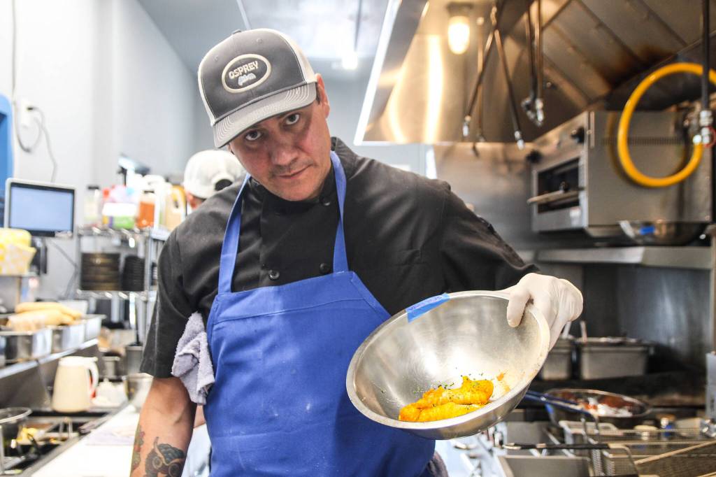Ben Jones poses with some tempura fried cod before he serves it with fries, Cajun remoulade and lemon.