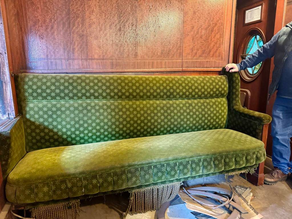 A bench set in parlor car 1049 with the original green mohair fabric, April 29, 2025.