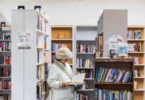 A woman flips through a book at the Good Cheer Thrift Store in Langley. (Olivia Vanni / The Herald)