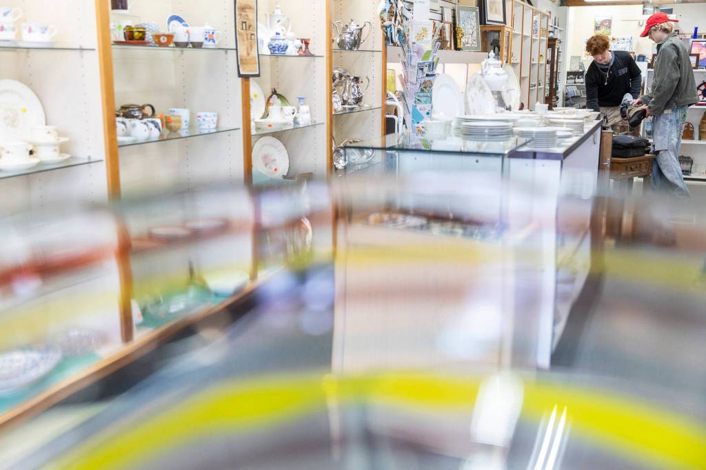 People look through shoes for sale at the Good Cheer Thrift Store. (Olivia Vanni / The Herald)