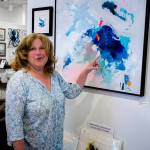 (Photo by David Welton)
Nancy Frances with Splash, her abstract piece with light and thick layers of paint that reminds her of dropping a rock into a pond.