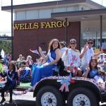 Young men and women wave from their parade float (Photo by Allyson Ballard)