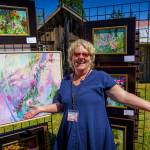 (Photo by David Welton) 
Artist Kim Stokely joyfully displays her art on the garden tour.