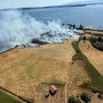 (Photo courtesy of South Whidbey Fire/EMS). This aerial view of the fire near Double Bluff Wednesday shows its scale and smokiness.