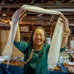 (Photo by David Welton) Sampa Lhundup drapes a visitor with a khata, a Tibetan Buddhism ceremonial scarf bearing the symbols for good luck and welcome.
