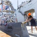 Mattie Hanley, wife of DARPA director Stephen Winchell, smashes a bottle to christen the USX-1 Defiant, first-of-its kind autonomous naval ship, at Everett Ship Repair on Monday, Aug. 11, 2025 in Everett, Washington. (Olivia Vanni / The Herald)
