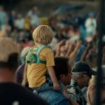 (Photo by Nathan Hamer) A boy sits on someones shoulders to get a better view of the performers above the packed audience at the Oak Harbor Music Festival.