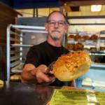 (Photo by David Welton) John Auburn serves up a cheese bagel at the Clinton shop.