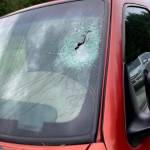 An image from a lawsuit shows a windshield allegedly smashed by a hose cap that came off a fire engine.