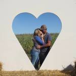 (Photo by Marina Blatt) Shannon and Steve Hilborn kiss behind a cut-out heart.