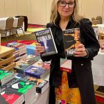 Kim Hornsby surrounded by her books at the Pacific Northwest Writers Association Writers Conference in 2025. (Photo provided)
