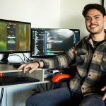 Luis Ortiz Orantes smiles in front of his workstation in his apartment, where he coded the app. (Photo provided.)