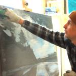 (Photo by Allyson Ballard) Haslet demonstrated his painting technique upon the <em>News-Times </em>visit, carefully dusting blue paint upon a canvas to carve out a skyline.
