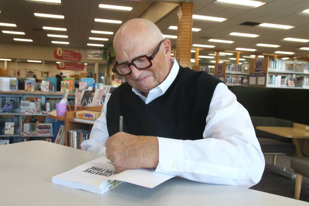 (Photo by Marina Blatt) Douglass Shaw signs a copy of his latest book, Curative Culture.