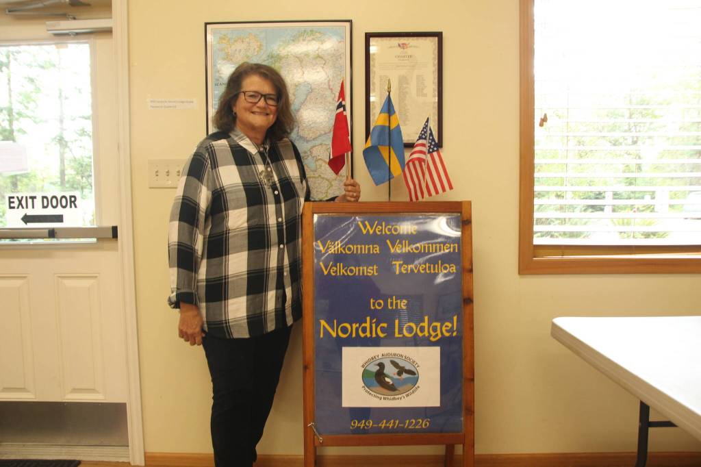 (Photo by Marina Blatt) The Whidbey Island Nordic Lodge President Kathy Smith stands next to nordic flags.
