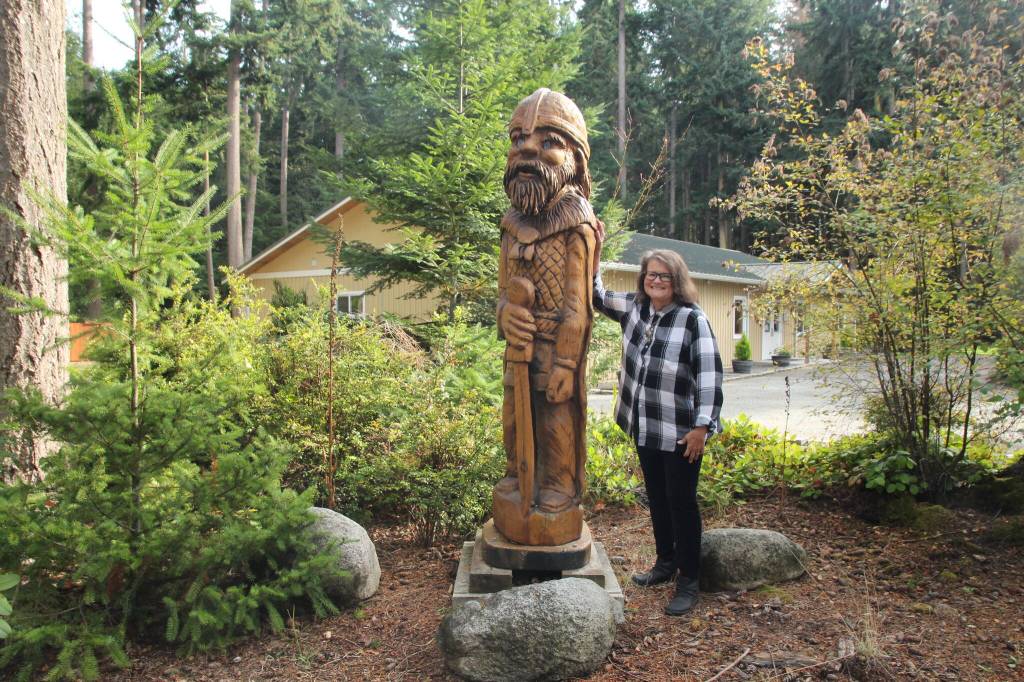 Photo by Marina Blatt
Smith appears small standing next to a carved wooden viking outside of the Whidbey Island Nordic Lodge.
