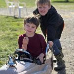 Graeme Auchterlonie, age 8, pushes Nels Auchterlonie, age 5, in a mini fire engine. (Photo by Beth Chamberlin)