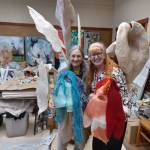 Holly Koteen-Soulé, left, and Melissa Koch with the heads of two puppets that will be part of the Festival of the Elements event. Behind them is a papier-mâché sculpture created by Kochs son-in-law. (Photo by Kira Erickson/South Whidbey Record)