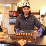 Jaden Varljen, an employee, serves up chocolates to customers.