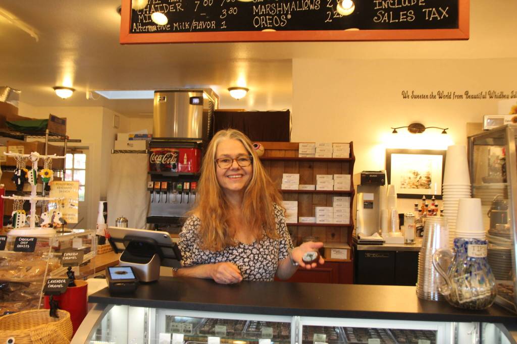 Photo by Marina Blatt
Newbauer greets customers behind the counter of Sweet Monas as she holds up the iconic whale cookie.