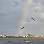 (Photo by Nichol Redfearin)	A kiteboarder launches into the air superman-style, with onlookers watching in awe.