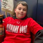 (Photo by Marina Blatt) Sam King wears his Diamond Dogs Jersey while holding up his signature hot sauce.