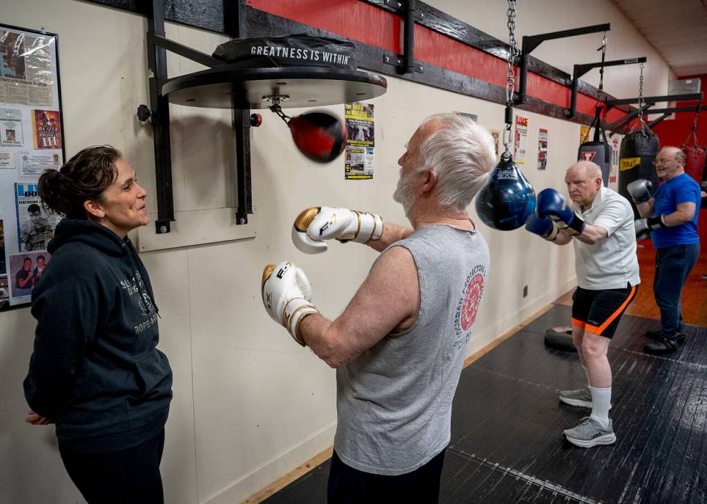 Lauren Stone looks on as Gary Goltz warms up. (Photo by David Welton)