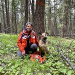 Alli Paul poses in the woods with her shepherd mix, Stella, after getting certified for K9 Search and Rescue.