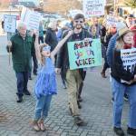 (Photo by Luisa Loi) South Whidbey School Board President Brook Willeford, holding a sign saying amplify youth voices, was among the community members who walked the streets of downtown Langley in February to protest deportations and the Trump Administration.