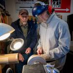 (Photo by David Welton) Don Wodjenski, left, shows Nathan Welton how to turn a wooden bowl on his lathe. Wodjenski is open to teaching more people who are interested in learning.