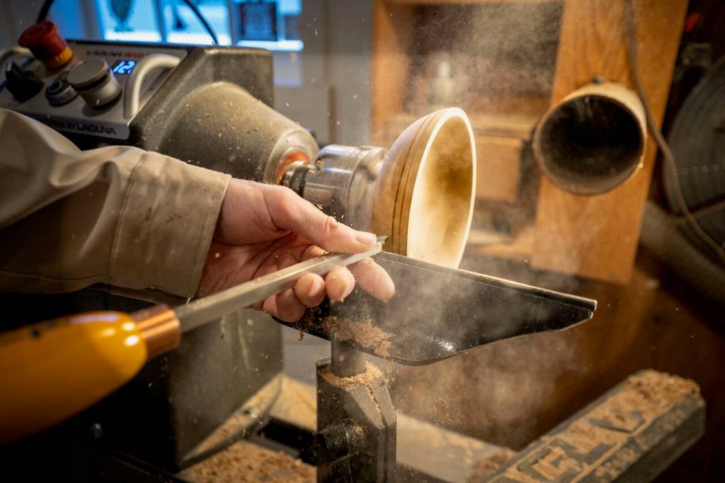 (Photo by David Welton) Large chisels are used to carve decorative lines all around the bowl.