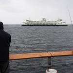 Will Geschke / The Herald
Amid cold, wind and rain, people fish along a pier in Edmonds while they watch a state ferry travel to Kingston on Nov. 17 in Edmonds.