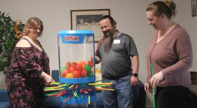 Photo by Marina Blatt. Staff members play a game of KerPlunk at the newly opened Our Hearts Together day center for adults. From left are Executive Director Kathie Rivas, Heartsong Homecare Cooperative Office Manager Desi Rivas and Marketing Director Kayla Wood.