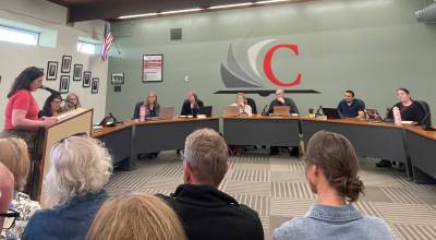 Photo by Marina Blatt. Coupeville Education Association Co-President Katja Willeford addressed a room filled with teachers and other staff, as well as students and parents. She warned that the cuts may fall disproportionately on employees working most closely with students.