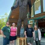 Photo provided. The newly installed 12-foot chainsaw-carved statue now stands outside Squatchys, a Washington state Sasquatch-themed store located at the entrance to Deception Pass State Park. From left are Ben Meaker, Kamber Meaker, Scott Meaker, Nathan Meaker and Nanette Meaker.