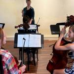Photos by Patricia Guthrie. Gracie Bystrom, at left, and Ruby Rundberg both play cello for the Salish Youth Symphony which practices weekly at The Whidbey Island School of Music and Dance in Freeland. Aniela Perry, who conducts the orchestra, is expanding programs at the community performance center.